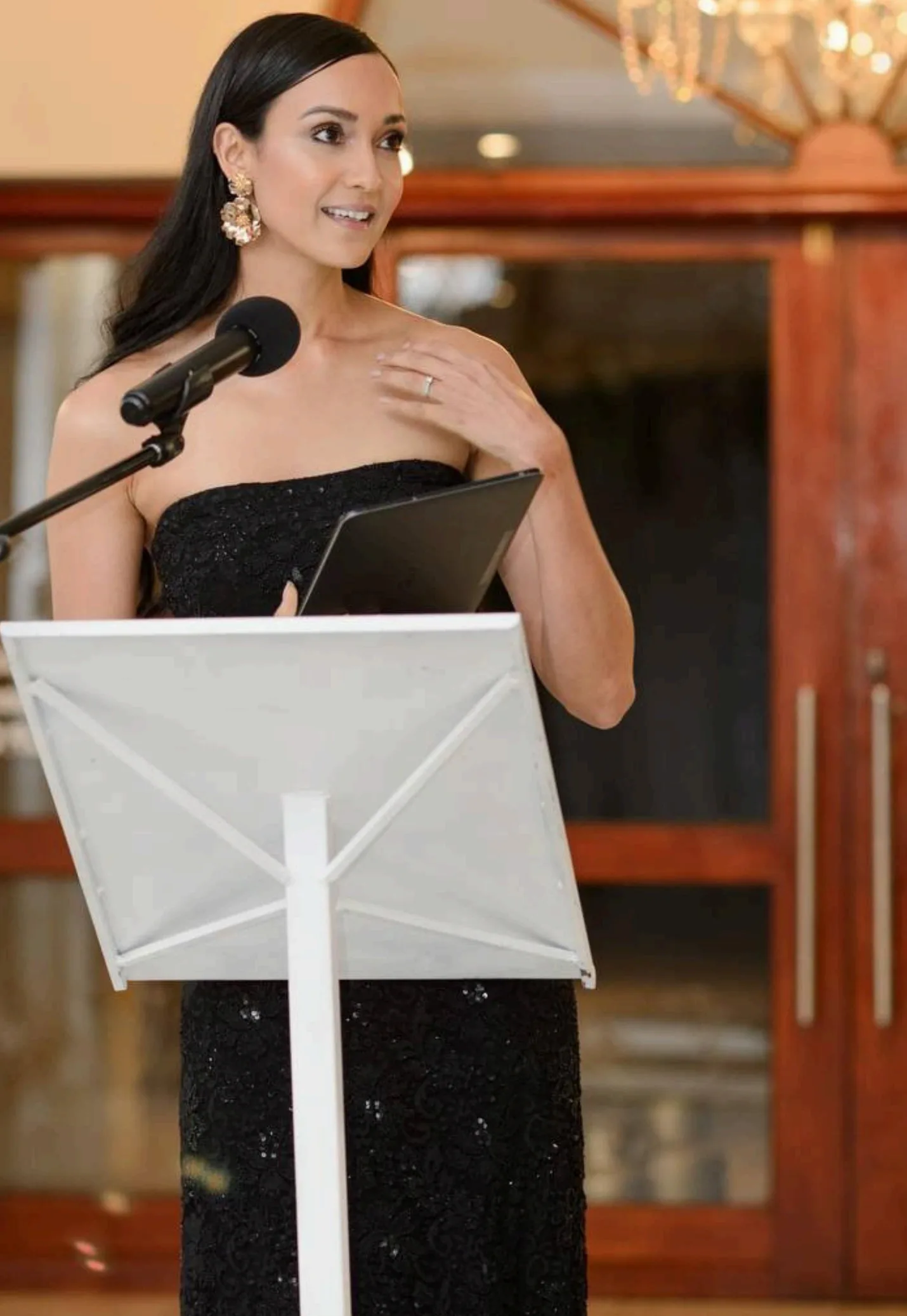 Mishka Loesch event host speaking at podium